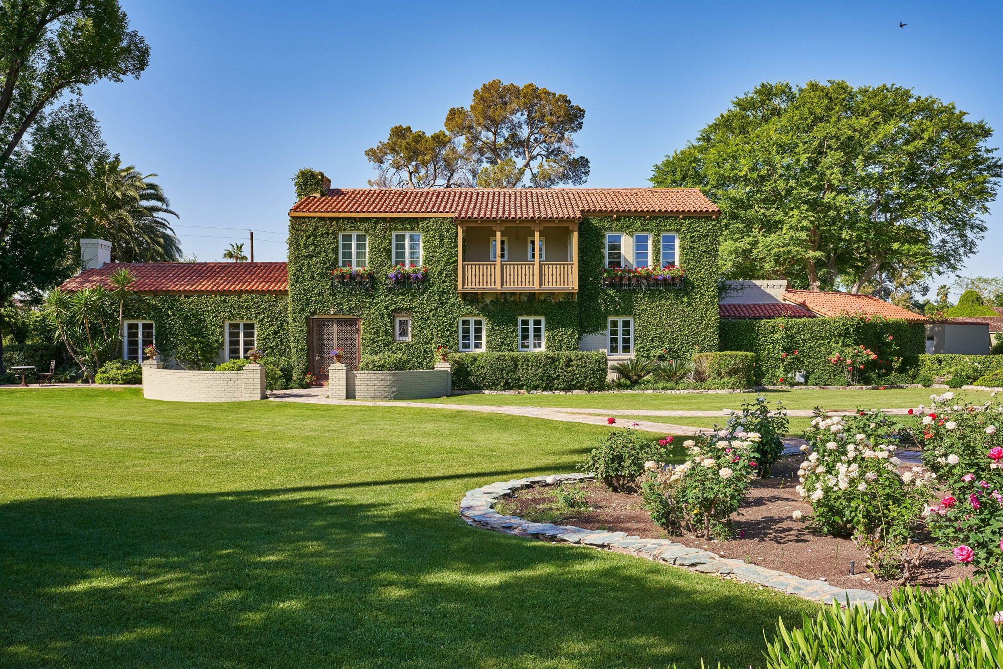 Ivy-covered Spanish Revival estate with tile roof and rose garden in historic Phoenix